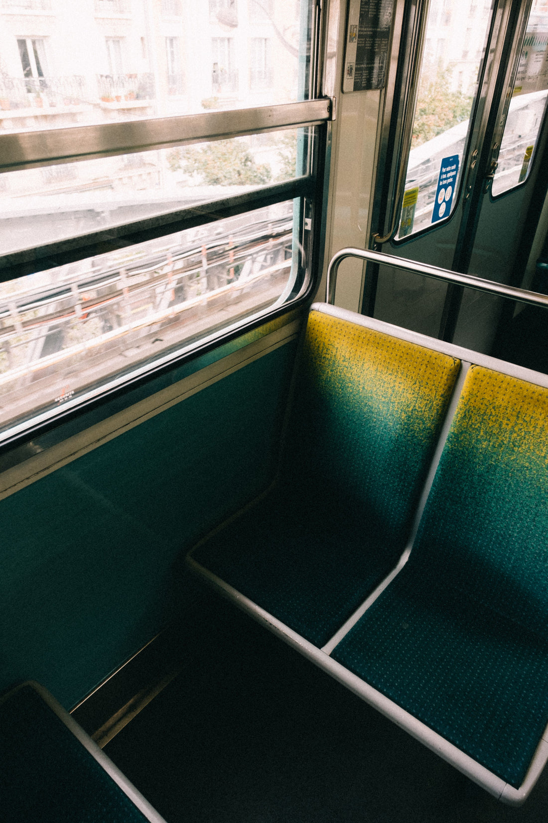An empty train seat beside a bright window in a quiet train car